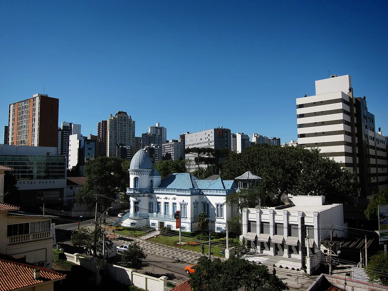 Castelo do Batel, mansão histórica de cúpula azul, com prédios altos do bairro Batel ao fundo, em Curitiba