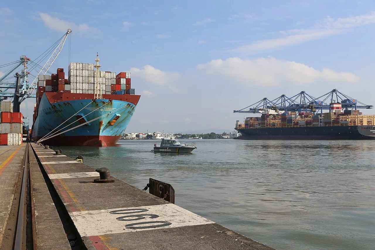 Navios porta-contêineres atracados no terminal do Porto de Itajaí, com guindastes e pilhas de contêineres às margens do rio Itajaí-Açu
